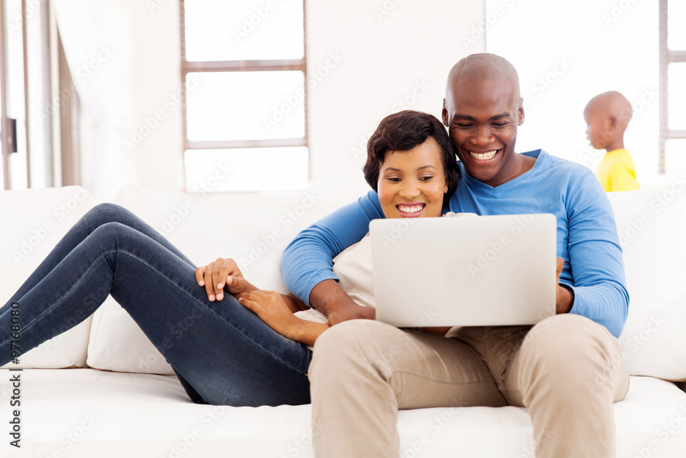 afro american couple using laptop at home