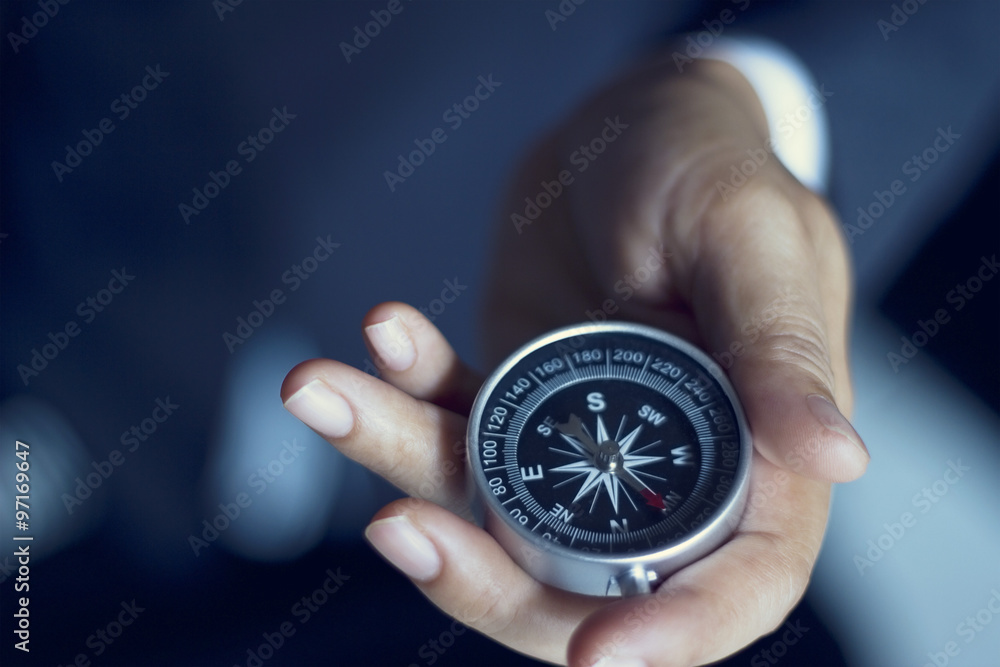 Businessman with a compass holding in hand, color tone film look Businessman with a compass holding in hand, color tone film look