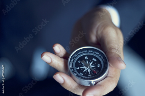 Businessman with a compass holding in hand, color tone film look photo