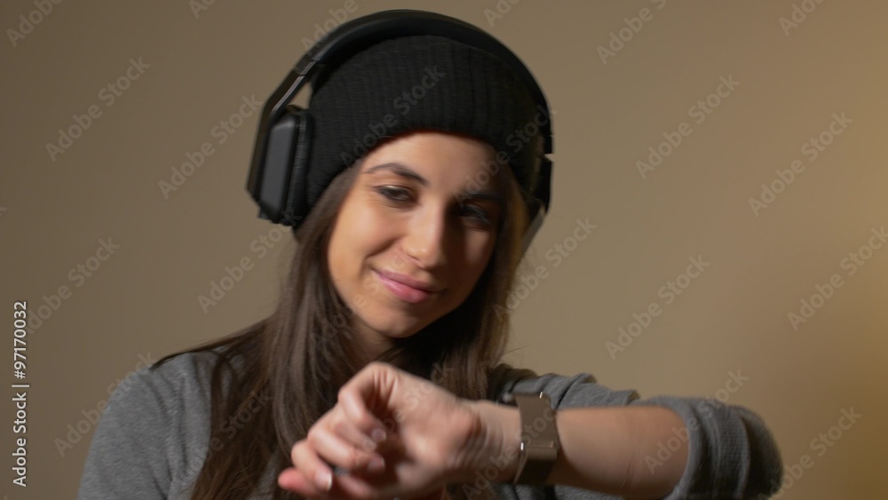 Hip young woman using smart watch keeps looking at camera Hip young woman using smart watch keeps looking at camera