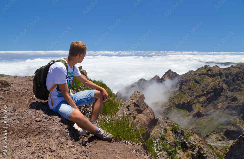 The tourist on Madeira has a rest, having got on the top located