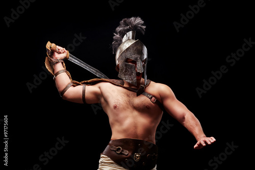 Gladiator with sword and armor on a black background