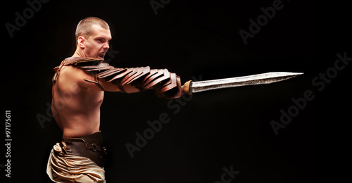 Obraz na płótnie Gladiator with sword and armor on a black background