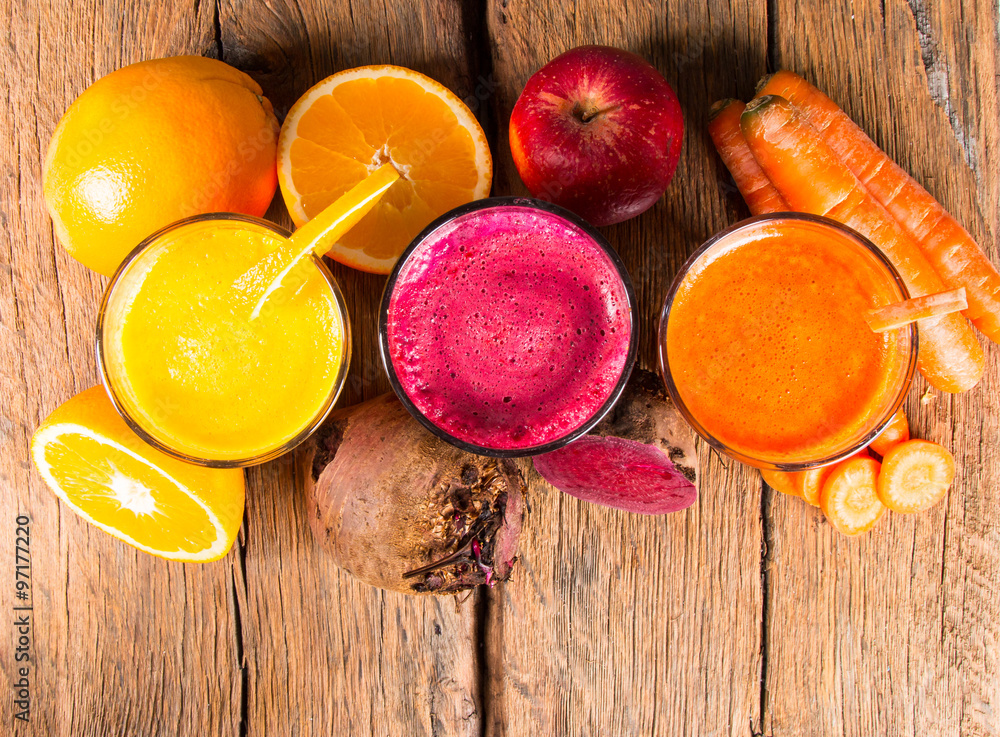 Fresh juice, mix fruits and vegetable, carrot, beetroot and orange drinks on wooden table. 