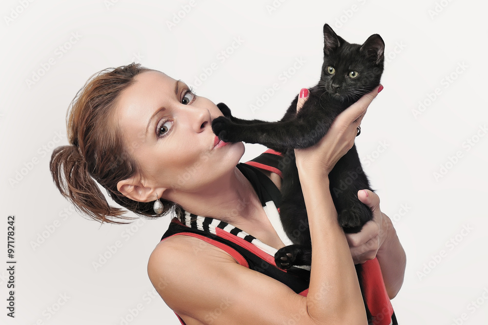 Attractive young woman holds a black kitten on hands. Attractive young woman holds a black kitten on hands.