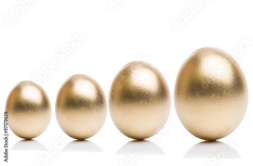 Golden eggs from small to large isolated on a white background. Concept of financial growth.