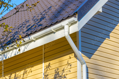Tiles on the roof and rain gutter  on the house upholstered with
