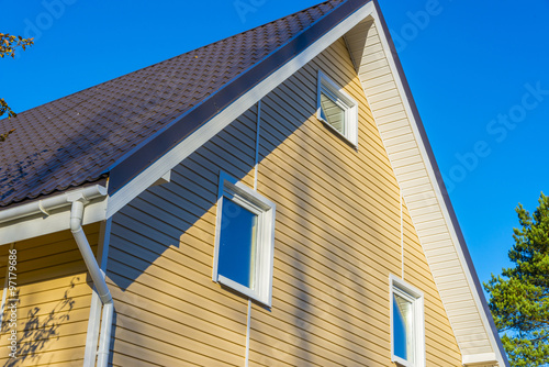 Tiles on the roof and rain gutter  on the house upholstered with