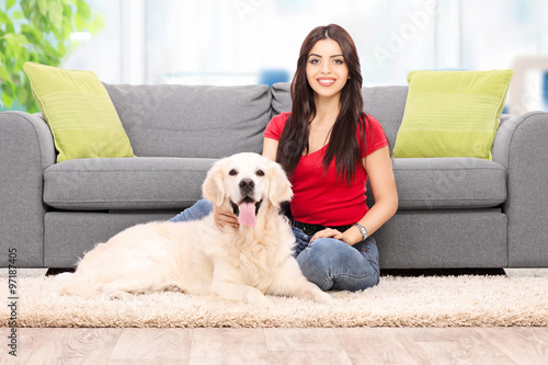 Young girl sitting with her dog at home