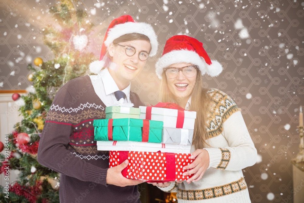 Smiling couple with santa hats holding gifts Smiling couple with santa hats holding gifts