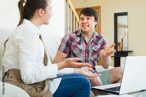 Girl talks with man while interviewing him at home photo