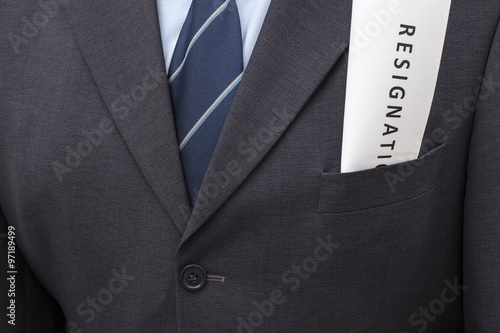 Folded letter of resignation, put in a jacket's pocket of a man. 