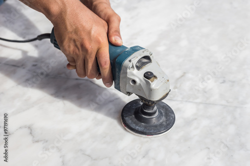 Man polishing marble table by angle grinder