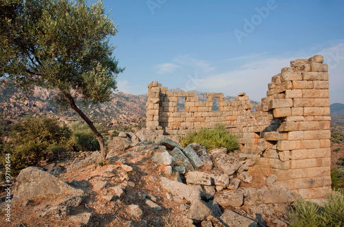 Abandoned house with broken walls of on the hill with olive trees