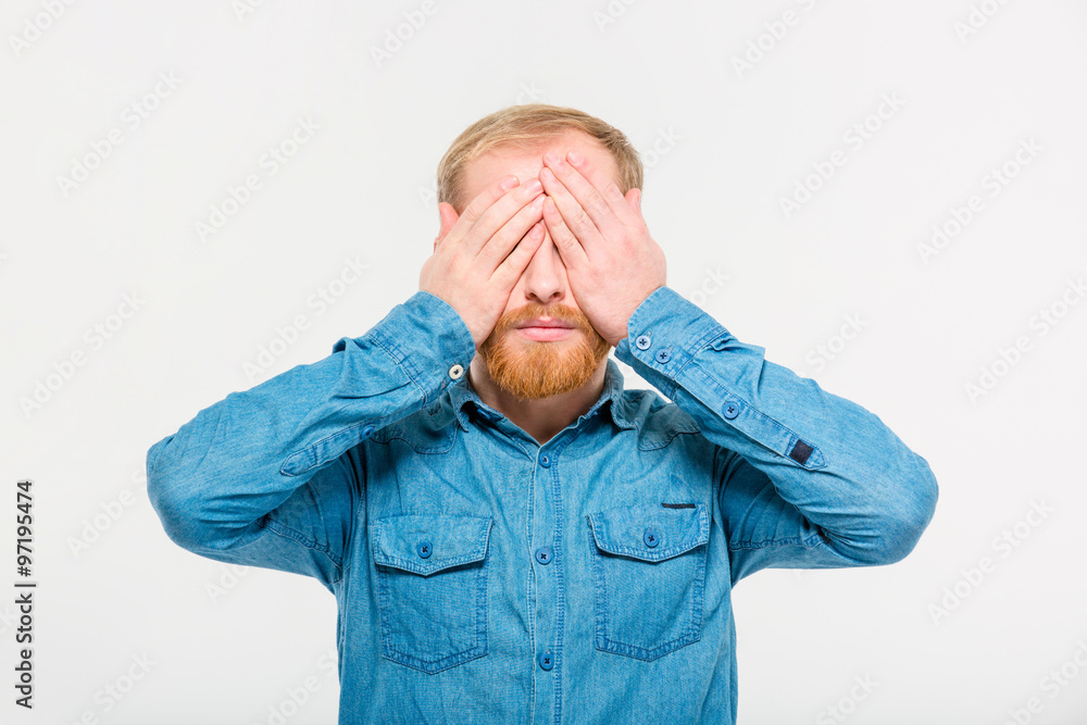 Young handsome blond bearded male with eyes covered by hands Young handsome blond bearded male with eyes covered by hands