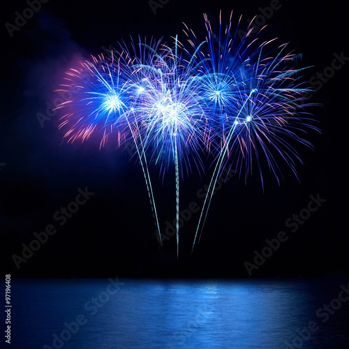 Blue fireworks above water