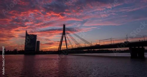 Time lapse of an epic sunset in Riga with suspension bridge and river Daugava in foreground photo