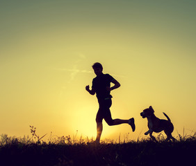 Running man with his dog sunset silhouettes