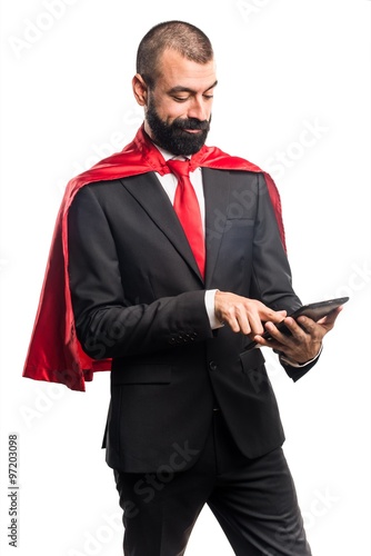 Super hero businessman holding a tablet