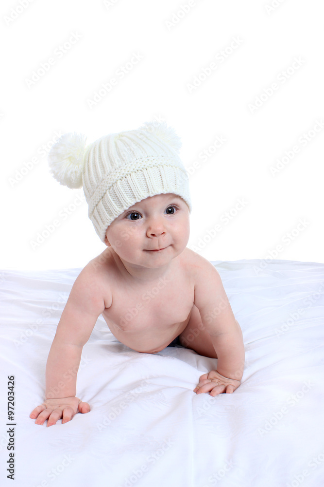 Portrait of adorable baby on the bed in the cap Portrait of adorable baby on the bed in the cap