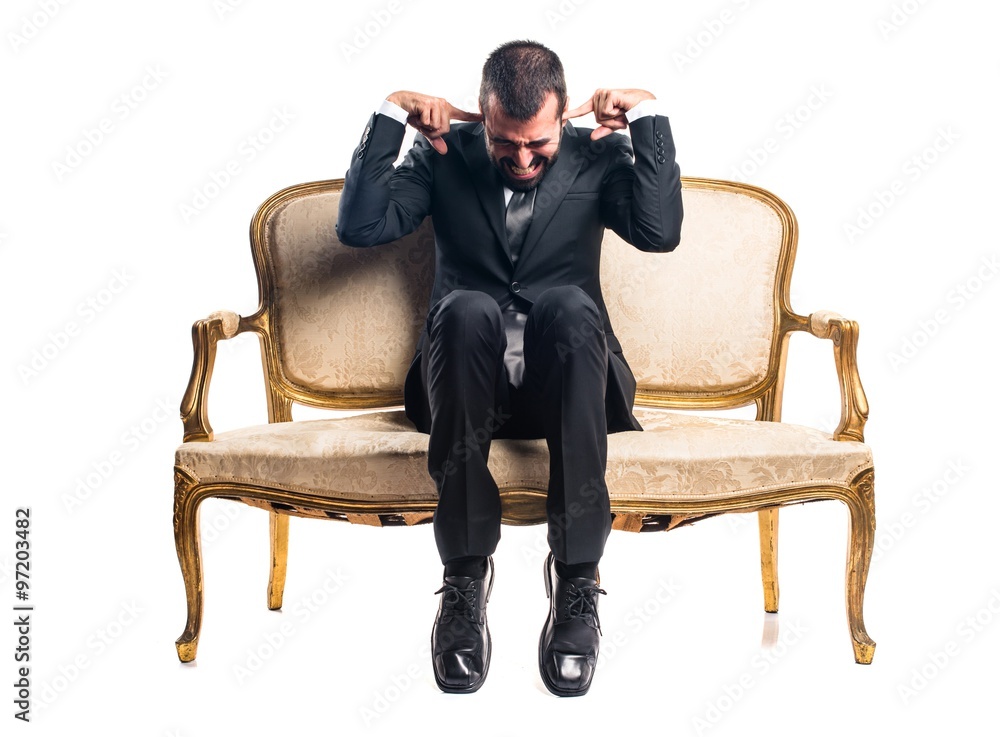 Businessman covering his ears Businessman covering his ears