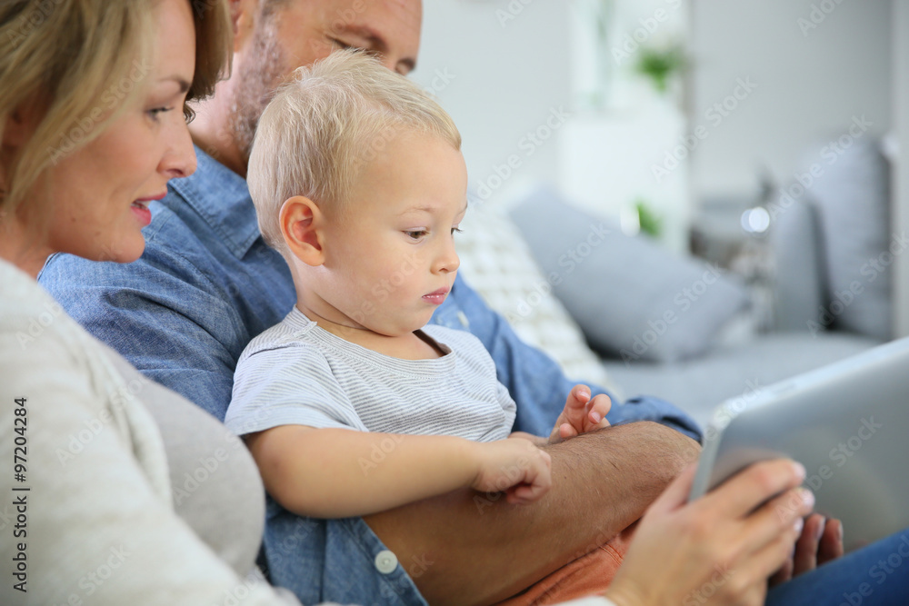 Parents with baby boy playing with digital tablet Parents with baby boy playing with digital tablet