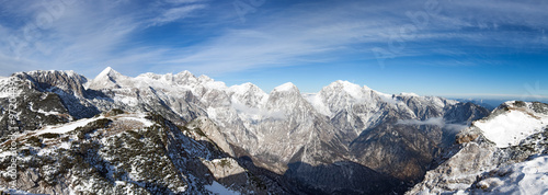Photo of a beautiful scene in European Alps. A view on the snow covered Kamnisko Savinjske alpe from the mountain Vrh Korena (altitude 1999 m).