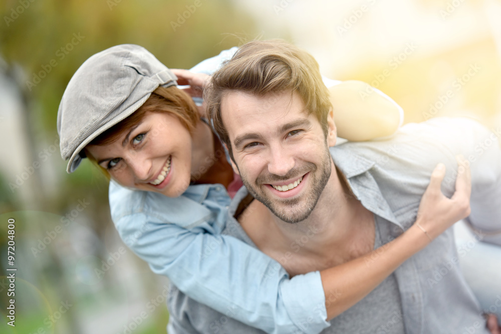 Portrait of man giving piggyback ride to girlfriend Portrait of man giving piggyback ride to girlfriend