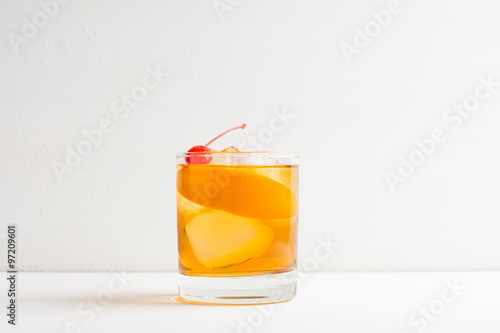 Old fashioned cocktail with cherry and orange peel