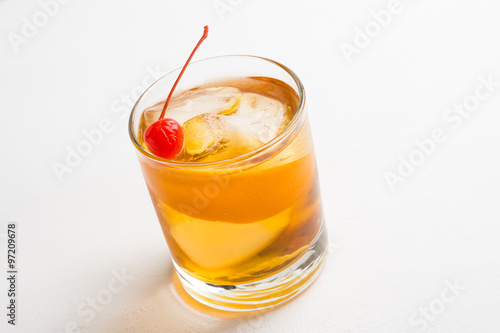 Old fashioned cocktail with cherry and orange peel