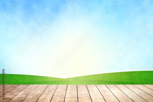 Wooden table with environmental on grassland field.