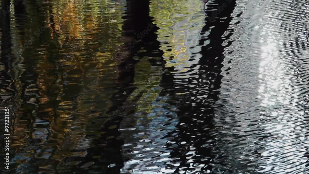 Water surface at windy sunset - trees and building reflections at small waves; abstract shapes; Water surface at windy sunset - trees and building reflections at small waves; abstract shapes;