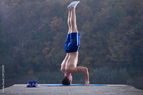 fitness man stand on the head outdoor