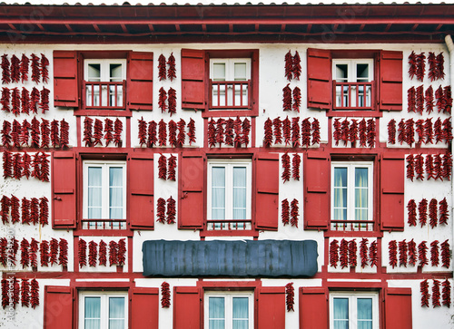 Red Espelette peppers drying in the wall of Basque house photo