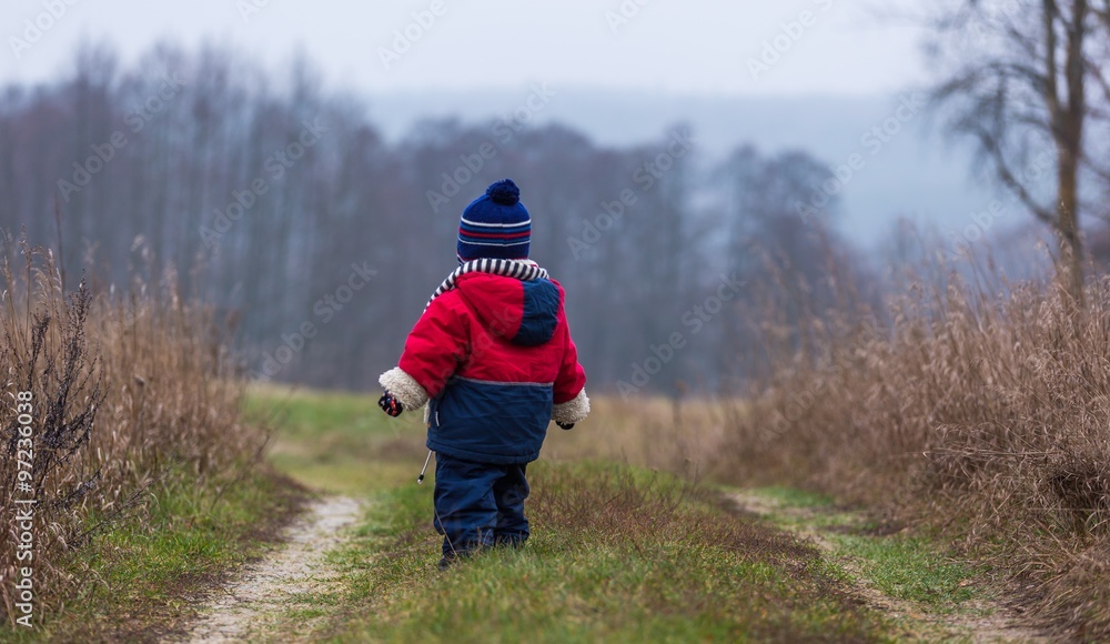 Child walking in countryside at autumnal bad weather Child walking in countryside at autumnal bad weather