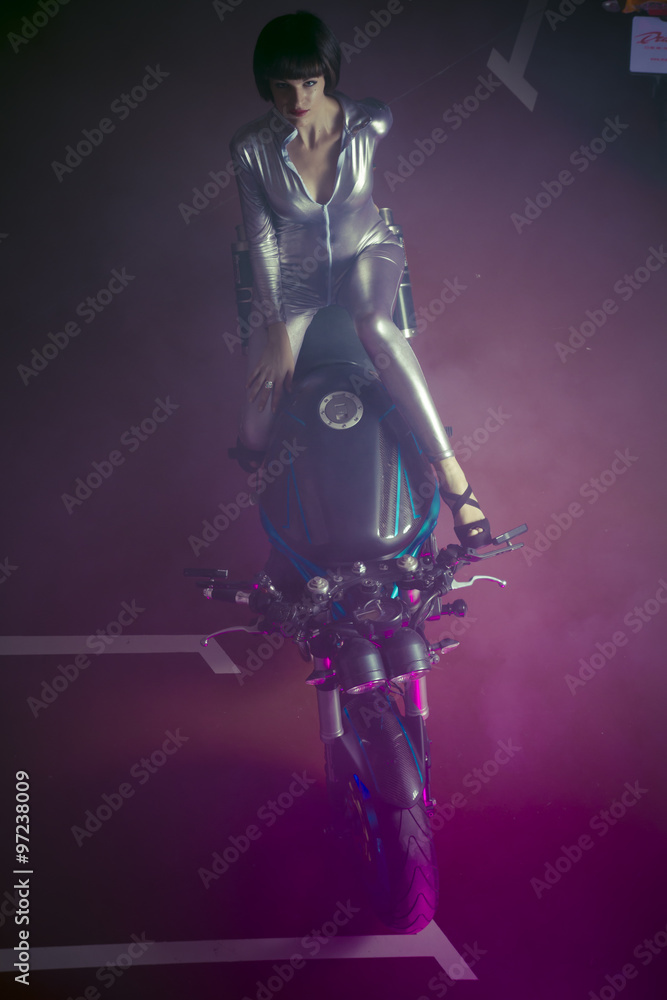 Naklejka premium brunette with latex suit mounted on a bike with a modern design