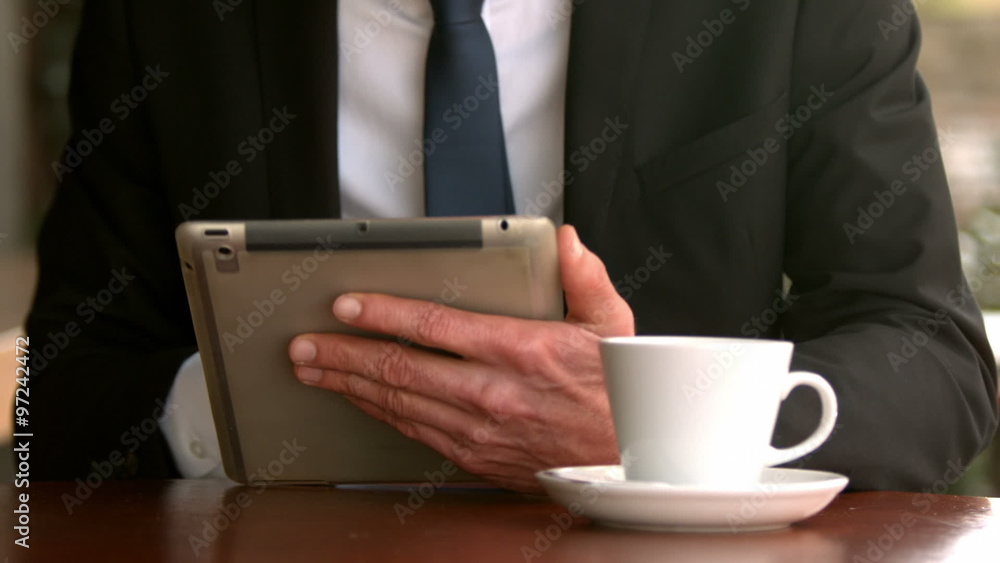 Handsome businessman using his tablet Handsome businessman using his tablet