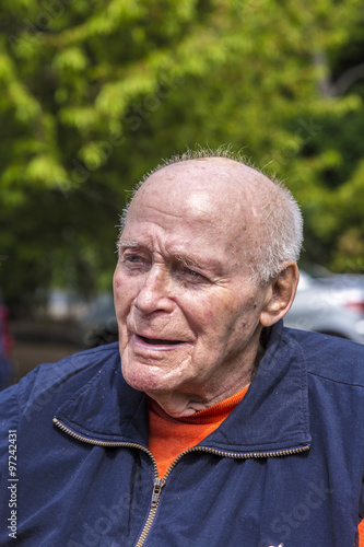 smiling happy senior man sitting in his garden