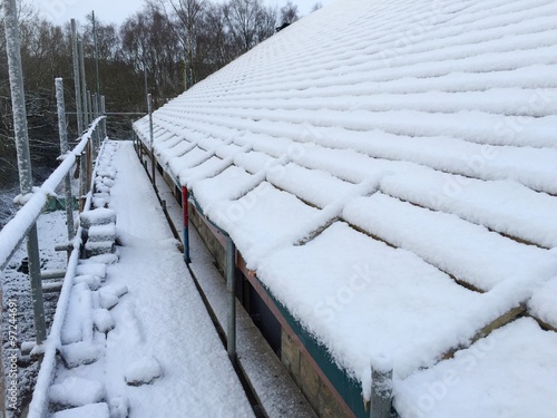 snow covered roof and scaffolding on a building site