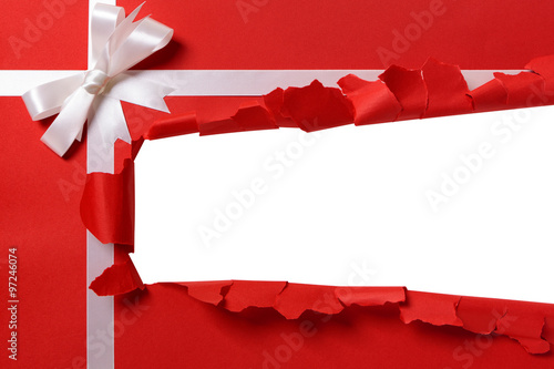 Christmas gift torn open strip, white ribbon bow, red wrapping paper