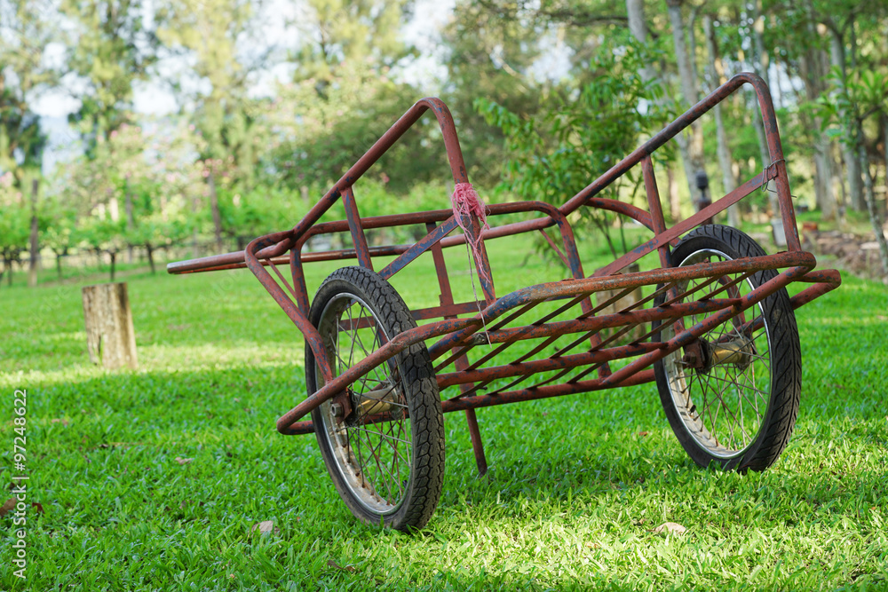 old red steel cart on the green grass field