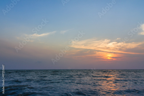 Sunset over the sea with clouds over the water surface