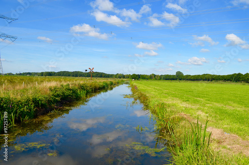 Vászonkép Ditch and green polder landscape in summer in the Netherlands