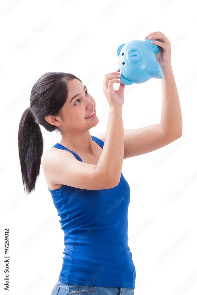 young woman trying to get some money out of piggy bank young woman trying to get some money out of piggy bank