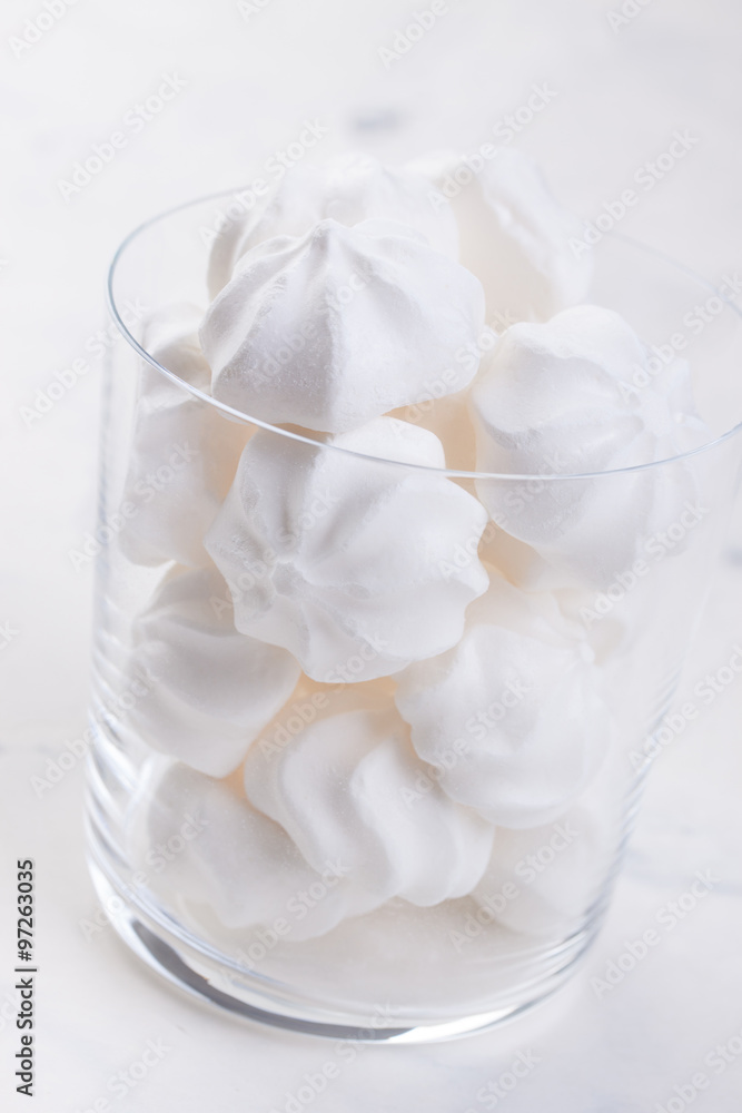 Closeup of meringue cookies in a glass on a white background. selective focus