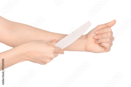 Health and hand care topic: a woman's hand holding a nail file for manicure isolated on white background in studio