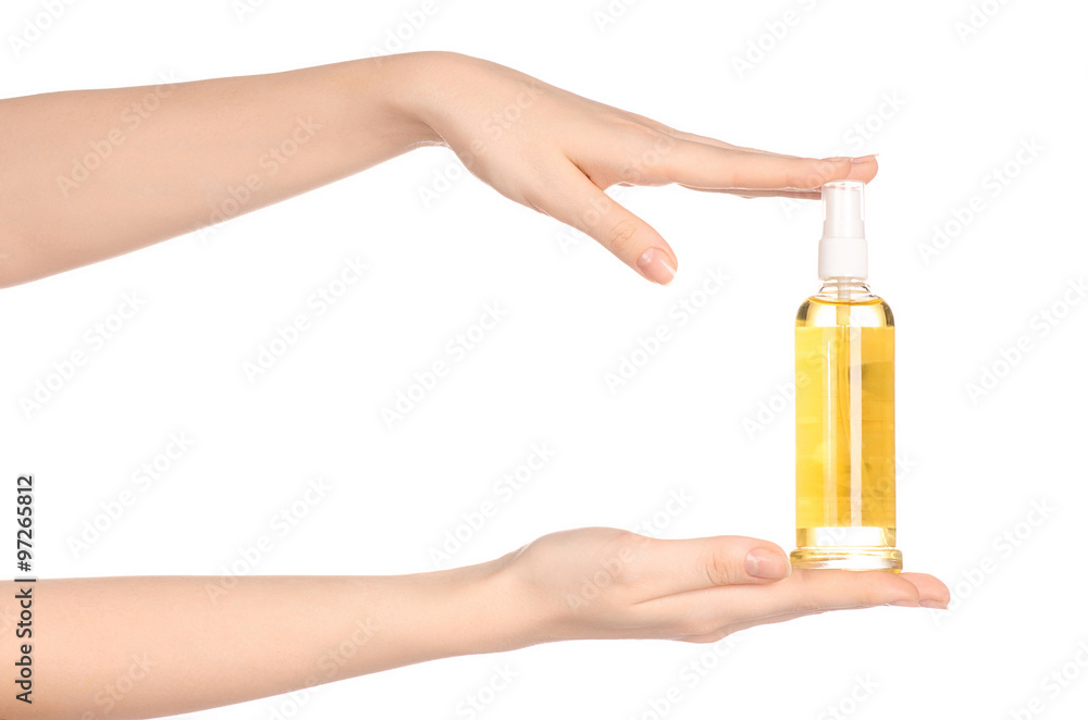 Fototapeta premium Massage and body care topic: a woman's hand holding a bottle of oil to the spa isolated on white background in studio