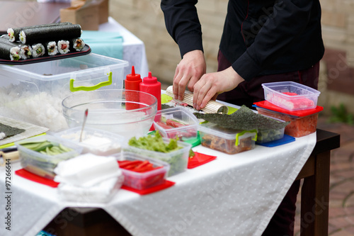 Master chef preparing delicious wedding sushi outdoors with a variety of ingredients