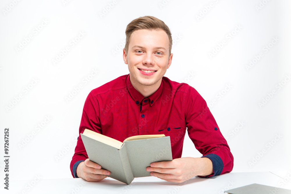 Happy smiling handsome man sitting and reading book