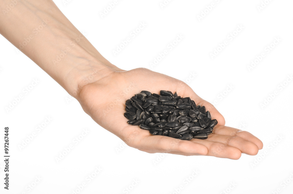 Nuts and meal preparation topic: human hand holding roasted sunflower seeds on a white isolated background in studio Nuts and meal preparation topic: human hand holding roasted sunflower seeds on a white isolated background in studio